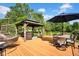 Spacious backyard deck with gazebo, dining area, and hanging chair, ideal for outdoor relaxation at 12945 E 100 N, Columbus, IN 47203