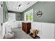 Charming bedroom features white wainscoting, wood furnishings, and ample natural light at 12945 E 100 N, Columbus, IN 47203