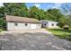 Exterior buildings of home with a gravel driveway surrounded by lush greenery at 12945 E 100 N, Columbus, IN 47203