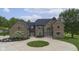 Stunning two-story brick home featuring a circular driveway and lush landscaping at 12945 E 100 N, Columbus, IN 47203