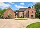 Stunning brick home featuring a circular driveway and beautiful landscaping at 12945 E 100 N, Columbus, IN 47203
