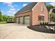 Three-car attached garage, adjacent to outdoor gazebo, complemented by professional landscaping at 12945 E 100 N, Columbus, IN 47203