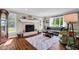 Cozy living room with fireplace, large windows, and hardwood floors at 12945 E 100 N, Columbus, IN 47203