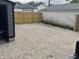 Gravel backyard with a new wooden fence and detached garage showing ample space for outdoor activities at 1417 N Belleview Pl, Indianapolis, IN 46222