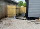 Enclosed backyard features new wooden fence, gravel, and an air conditioning unit to the side at 1417 N Belleview Pl, Indianapolis, IN 46222