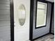 Close-up of the front door with an decorative glass window and modern gray siding at 1417 N Belleview Pl, Indianapolis, IN 46222