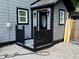 Back of property with gray wood and black trim, a porch, and gravel landscaping to the rear entryway at 1417 N Belleview Pl, Indianapolis, IN 46222