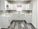 Newly renovated kitchen featuring white cabinetry, modern backsplash, and gray flooring at 1417 N Belleview Pl, Indianapolis, IN 46222