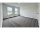 A bright bedroom featuring neutral carpeting, two windows with natural light, and white trim at 1534 Trichel Dr, Greenwood, IN 46143