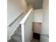 Staircase featuring neutral walls, carpeted steps, and white railing, offering a safe and stylish transition between floors at 1534 Trichel Dr, Greenwood, IN 46143