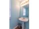 Stylish powder room with a sleek pedestal sink, a large mirror, and ample natural light from the window at 1603 Quinn Creek Dr, Brownsburg, IN 46112