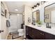 Modern bathroom with double sinks, decorative mirrors, updated lighting, and tiled shower at 1609 S G St, Elwood, IN 46036