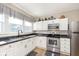 Bright kitchen with white cabinetry, a stainless steel stove, and black countertops at 1609 S G St, Elwood, IN 46036