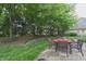Outdoor patio area for dining and relaxing, set among mature trees and greenery at 1614 Rosebud Ln # 83, Greenwood, IN 46143