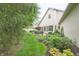 Manicured backyard featuring a brick house, lush lawn, and well-maintained landscaping at 1614 Rosebud Ln # 83, Greenwood, IN 46143