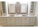 Elegant bathroom with dual sinks, granite countertops, wood-style accent wall, and storage cabinets at 1614 Rosebud Ln # 83, Greenwood, IN 46143