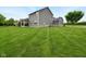 Well-maintained backyard with an expansive lawn, covered patio, and privacy, ideal for outdoor activities at 165 N Bend Dr, Greenwood, IN 46142