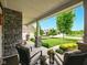 Inviting covered front porch with comfortable seating overlooking beautifully landscaped front yard at 165 N Bend Dr, Greenwood, IN 46142