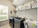 Functional laundry room with modern washer and dryer, utility sink, and ample storage shelving at 165 N Bend Dr, Greenwood, IN 46142