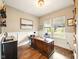 Home office featuring wood floors, wainscoting, a large desk, and plenty of natural light at 165 N Bend Dr, Greenwood, IN 46142