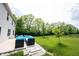 A backyard boasts a concrete patio with cushioned seating, lush lawn, and mature trees, perfect for outdoor living at 17696 Arryne E Dr, Noblesville, IN 46062