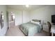 A bright bedroom with a bed, desk, and mirror provides a welcoming atmosphere at 17696 Arryne E Dr, Noblesville, IN 46062