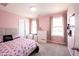 Bright bedroom with two windows, pink walls and carpet, and neutral-colored curtains at 17696 Arryne E Dr, Noblesville, IN 46062