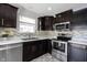 Kitchen with stainless steel appliances, dark cabinets, and tile backsplash at 17696 Arryne E Dr, Noblesville, IN 46062