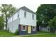 Charming two-story home with white siding, black accents, and a bright yellow front door at 1802 Woodlawn Ave, Indianapolis, IN 46203