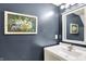 Stylish half-bathroom featuring navy blue walls, white fixtures, and decorative art print at 18258 Rickety Dr, Westfield, IN 46074