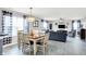 Open-concept living room with a dining area, gray walls, and lots of natural light from large windows at 18258 Rickety Dr, Westfield, IN 46074