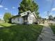 Quaint home with a sunroom addition, lush lawn, mature trees, and a cozy front porch at 1830 Jefferson St, Anderson, IN 46016