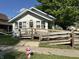 Charming home with a ramped porch, surrounded by mature trees and a well-maintained front yard at 1830 Jefferson St, Anderson, IN 46016