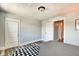 Neutral bedroom featuring laminate floors, white doors, gray walls, and a glimpse into a bathroom at 1867 Barth Ave, Indianapolis, IN 46203