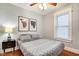 Relaxing bedroom with neutral tones, wood floors, a ceiling fan, and a window offering plenty of natural light at 1867 Barth Ave, Indianapolis, IN 46203