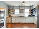 Modern kitchen with stainless steel appliances, wooden shelves, and white cabinets, maximizing space and functionality at 1867 Barth Ave, Indianapolis, IN 46203
