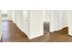 Hallway with hardwood floors, white doors, and a view into a carpeted room at 19725 Highclere Lane, Sheridan, IN 46069