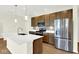 Modern kitchen featuring a large stainless steel refrigerator, a gas range and wooden cabinets with light countertops at 19725 Highclere Lane, Sheridan, IN 46069