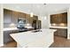 Modern kitchen showcases a central island with a sink, complemented by stainless steel appliances and pendant lighting at 19725 Highclere Lane, Sheridan, IN 46069