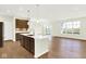 Open-concept kitchen featuring a central island with sink, stainless appliances, and adjacent dining and living areas at 19725 Highclere Lane, Sheridan, IN 46069