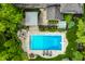 Aerial view of the house with a backyard pool, a hot tub, and lush landscaping, surrounded by green trees at 2055 Mulsanne Dr, Zionsville, IN 46077