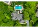 Aerial view of the house with a backyard pool, a hot tub, and lush landscaping, surrounded by green trees at 2055 Mulsanne Dr, Zionsville, IN 46077