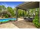 Inviting backyard featuring a pool, covered patio, outdoor seating, and lush greenery at 2055 Mulsanne Dr, Zionsville, IN 46077