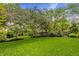 Expansive green backyard showcasing well-maintained lawn, mature trees and lush landscaping at 2055 Mulsanne Dr, Zionsville, IN 46077