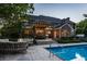 A spacious backyard featuring a pool, an outdoor kitchen and dining area, and a cozy seating area at 2055 Mulsanne Dr, Zionsville, IN 46077