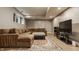 Basement features a plush sectional couch, TV area and a decorative area rug at 2055 Mulsanne Dr, Zionsville, IN 46077
