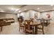 Open basement with a dining table and ping pong table near a large comfortable sectional sofa at 2055 Mulsanne Dr, Zionsville, IN 46077