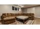 Basement sectional couch and ottoman accented by a detailed area rug near a window at 2055 Mulsanne Dr, Zionsville, IN 46077
