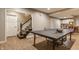 Finished basement with a ping pong table, kitchenette, stairs and vinyl flooring at 2055 Mulsanne Dr, Zionsville, IN 46077