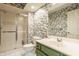 Bathroom with a glass door shower, patterned wallpaper, and a single sink vanity at 2055 Mulsanne Dr, Zionsville, IN 46077